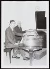 Photograph of School of Music Assistant Dean Charles Stevens and Dean Everett Pittman seated at two pianos
